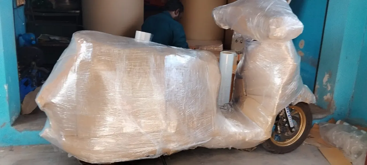 Scooter fully wrapped in cardboard and stretch film for transport